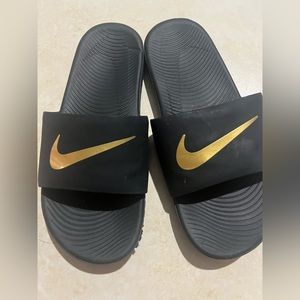 Nike gold slides.